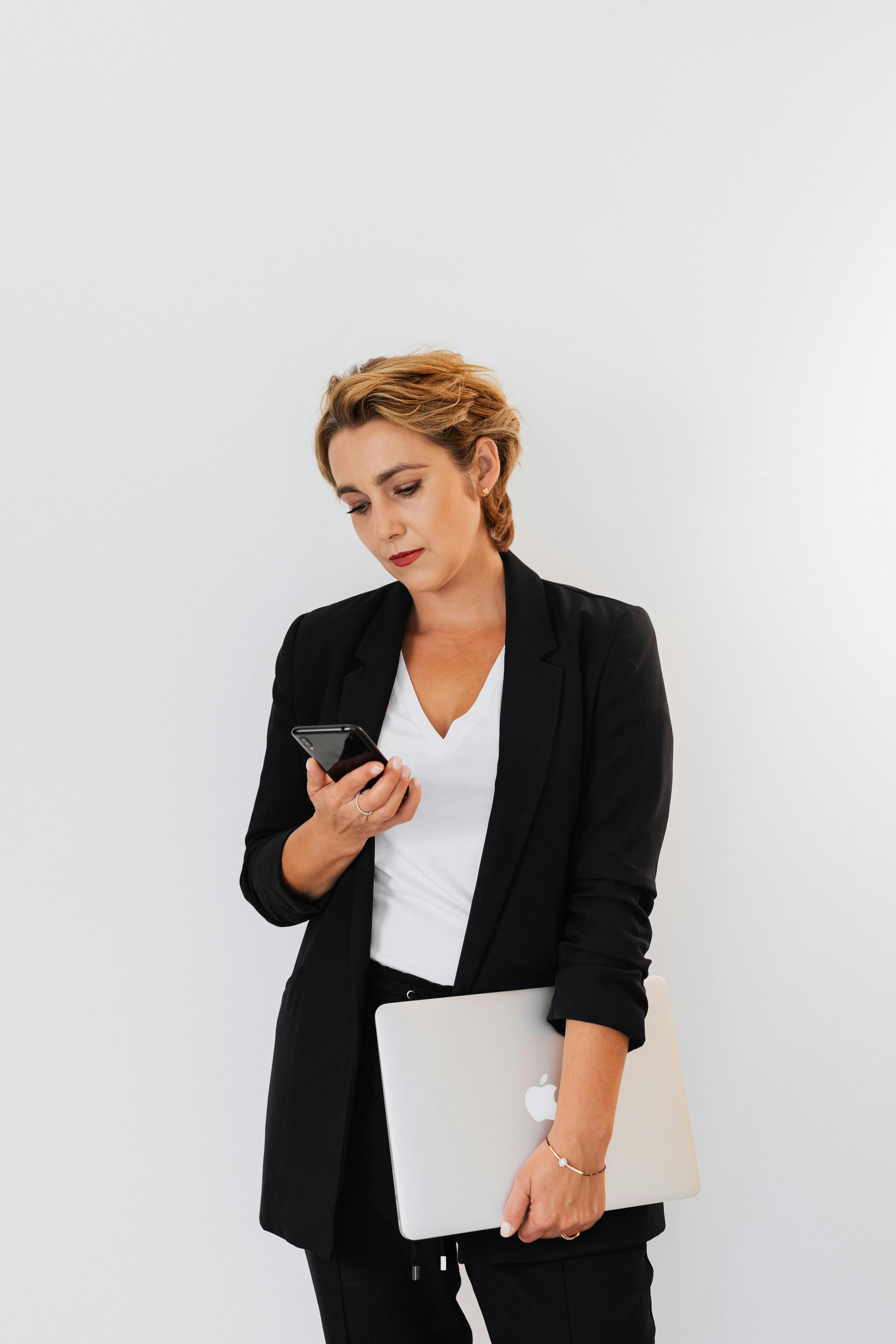 Ubigi eSIM'i iş ve uluslararası seyahat için temsil eden telefon ve dizüstü bilgisayar tutan profesyonel gezgin